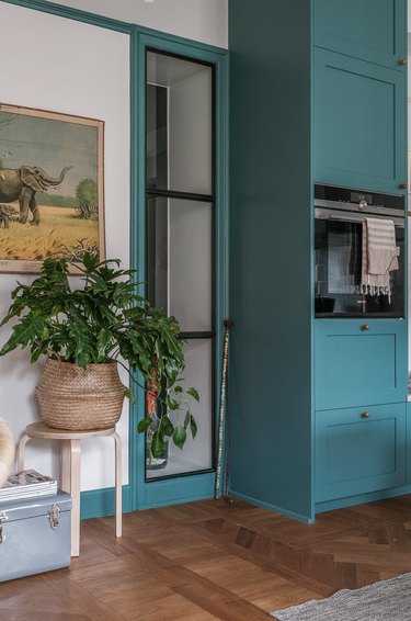 Room with gray wall and teal cabinets and molding
