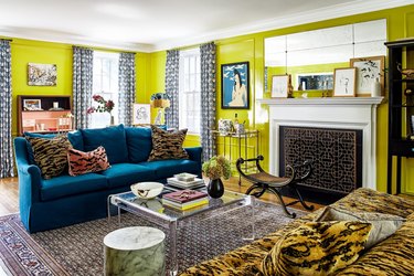 Room with chartreuse walls, a turquoise sofa, and animal print accents