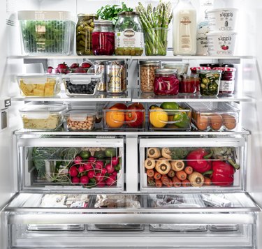 Refrigerator organized with clear containers and clear bins.