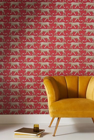 Mustard velvet chair against red wallpaper with jaguars