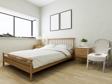 A bedroom with a bed nightstand and commode