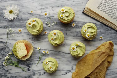 DIY sage green frosted cupcakes garnished with chamomile flowers