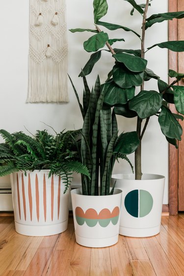A trio of faux plants in painted pots.