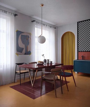 Dining room with mid-century modern dining set, burgundy tiles, yellow curtain, art, pendant lamp.