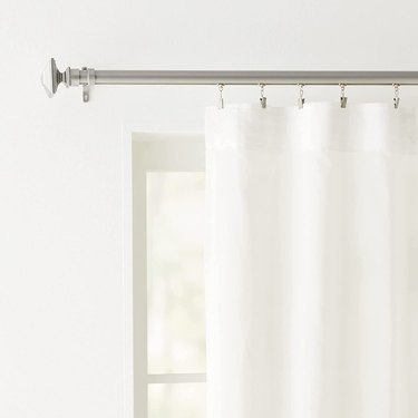 traverse curtain rod with white curtain hanging