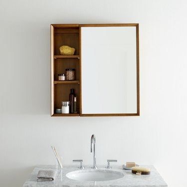 midcentury-style medicine cabinet with a wooden frame and shelves
