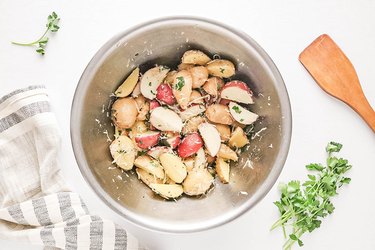Baby potatoes, spices, and Parmesan cheese in a bowl