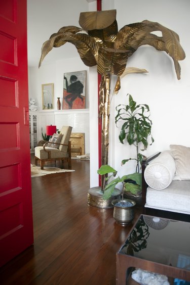 A brass banana tree and bench sit by the entryway