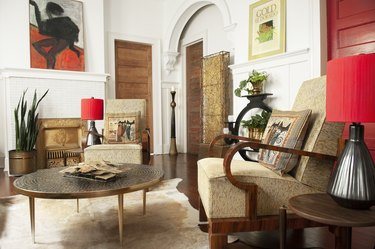 The great room of Carly Sioux's New Orleans apartment, which has seating and a round coffee table, with red doors nearby