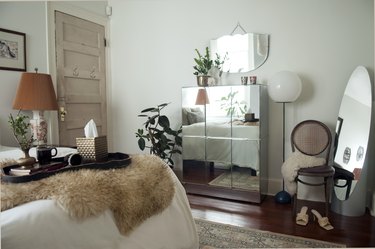 Mirrored furnishings in a bedroom space near mirrors and a chair