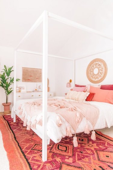 white boho bedroom with pink and coral soft furnishings