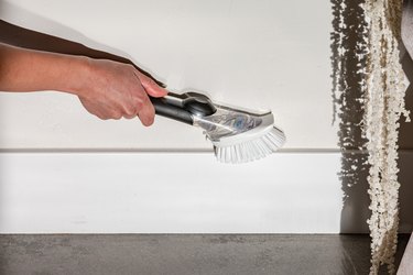 cleaning baseboards with kitchen scrubber