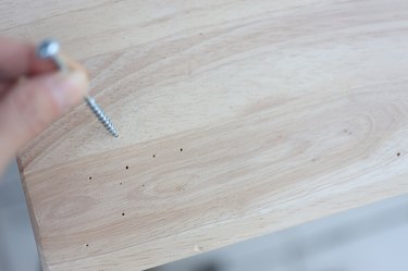 Holes punctured in the wood with a screw and hammer