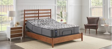Gray mattres on wood frame bed