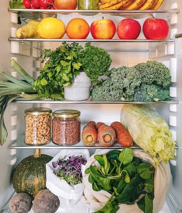 Interior of refrigerator featuring fresh fruit and vegetables.