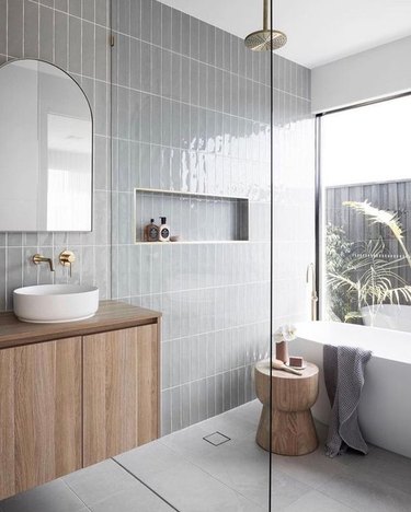 gray bathroom with wet room that includes both a shower and freestanding tub
