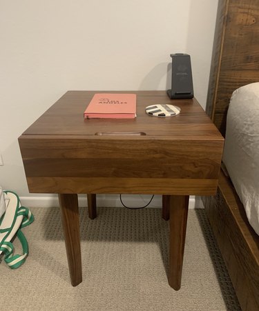dark wood nightstand with book on it