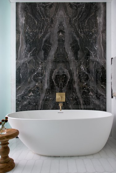 Bath tub with black marble backsplash
