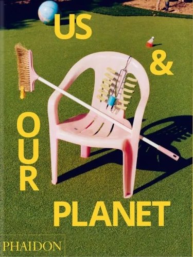 Book cover of "Us & Our Planet" featuring a pink plastic chair on grass.
