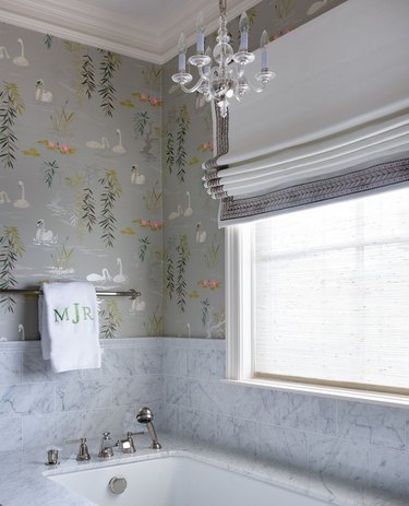 Pretty bathroom with bird wallpaper and a chandelier