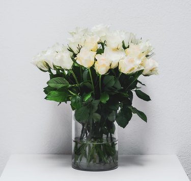 A bouquet of white roses in a clear vase.