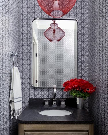 Small black and red powder room sink area