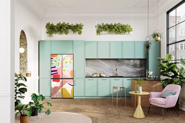 kitchen with green cabinets and a colorful, artsy refrigerator