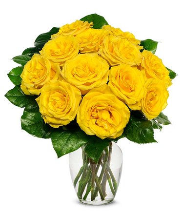 A dozen yellow roses and their green leaves arranged in a clear vase.