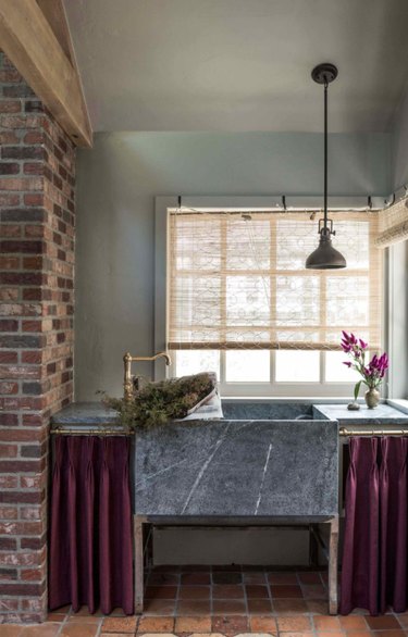 Kitchen with gray marble sink, bricks.