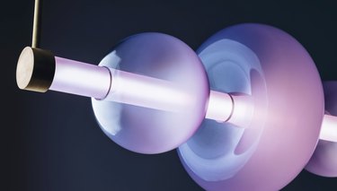 A purple light fixture featuring several donut-shaped pieces along an LED rod.
