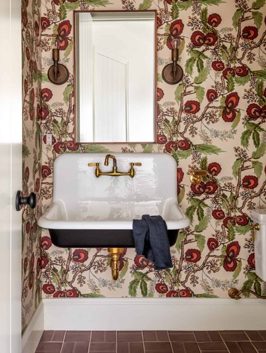Powder room with burgundy and green wallpaper.