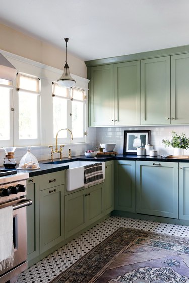 Kitchen with green cabinets and penny tile floor
