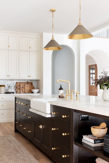 Designer kitchen with brown island and hangin lights