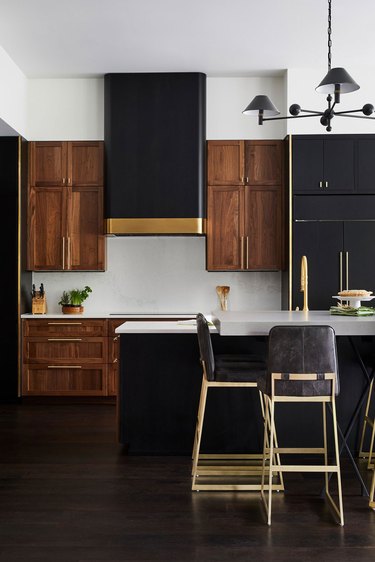 Modern kitchen with wood cabinets and gold vent hood