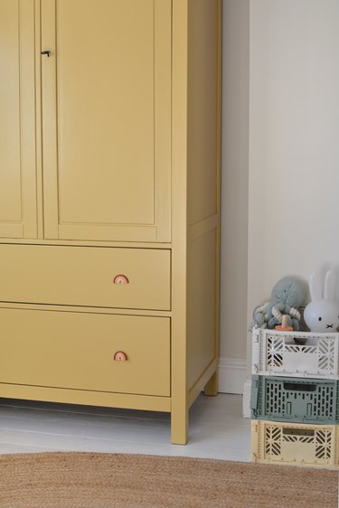 Yellow wardrobe with rainbow drawer knobs