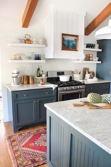 Coastal kitchen with blue cabinets and wood beams