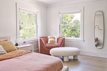 parents' bedroom with accent chair and ottoman near the windows