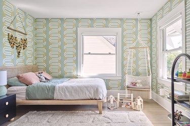 toddler's bedroom with hanging chair and green patterned wallpaper