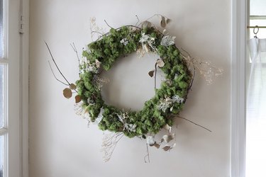 DIY moss and dried floral wreath hanging on wall