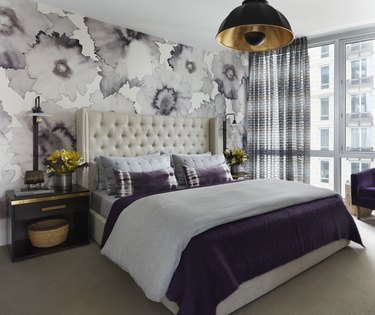 Bedroom with white bed and purple wallpaper and bedding