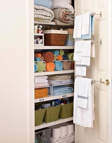 Linen closet with towel racks, bins.