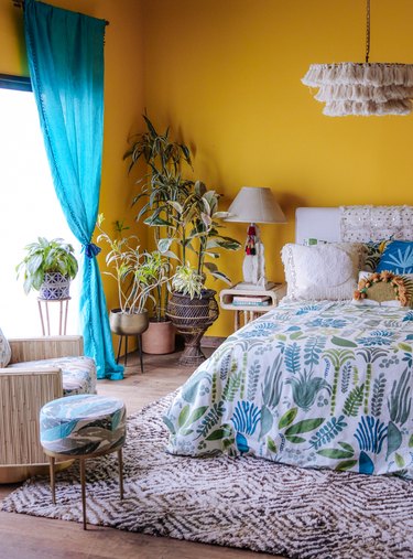 mustard yellow bedroom wall with turquoise curtains