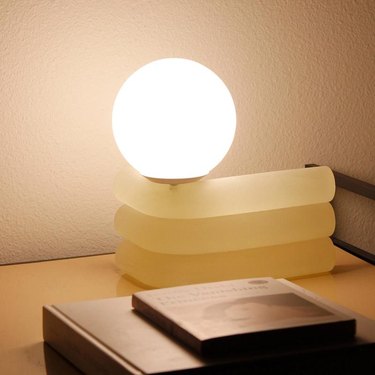 elio lamp with globe light near books