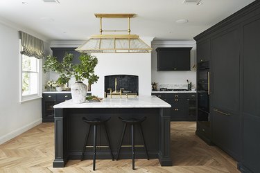 Kitchen with wood floors and black cabinets.