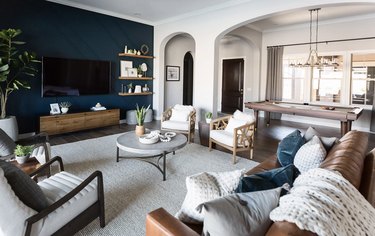 Living room with navy wall and dark wood floors.