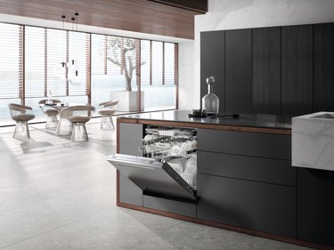 Miele built-in dishwasher in a kitchen with black cabinets