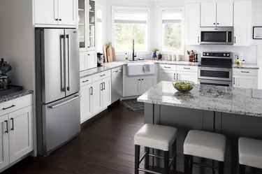 Kitchen with a silver refrigerator and marble kitchen island