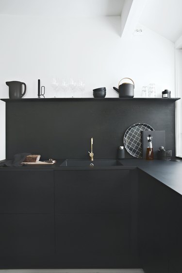 monochrome kitchen with black stained plywood backsplash
