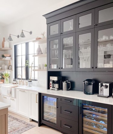 Black and white kitchen with sink, cabinets, coffee maker.