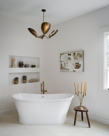 chandelier hanging from ceiling over freestanding bathtub